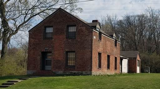 A brick house with a garage and a garage

AI-generated content may be incorrect.