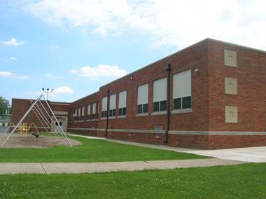 A school building with a playground

AI-generated content may be incorrect.