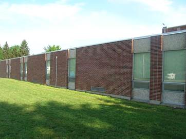 A brick building with a lawn

AI-generated content may be incorrect.